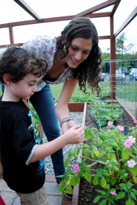 HELPING HAND: A student shows a child around the school edible garden, paid for by Green Village Initiative (GVI).